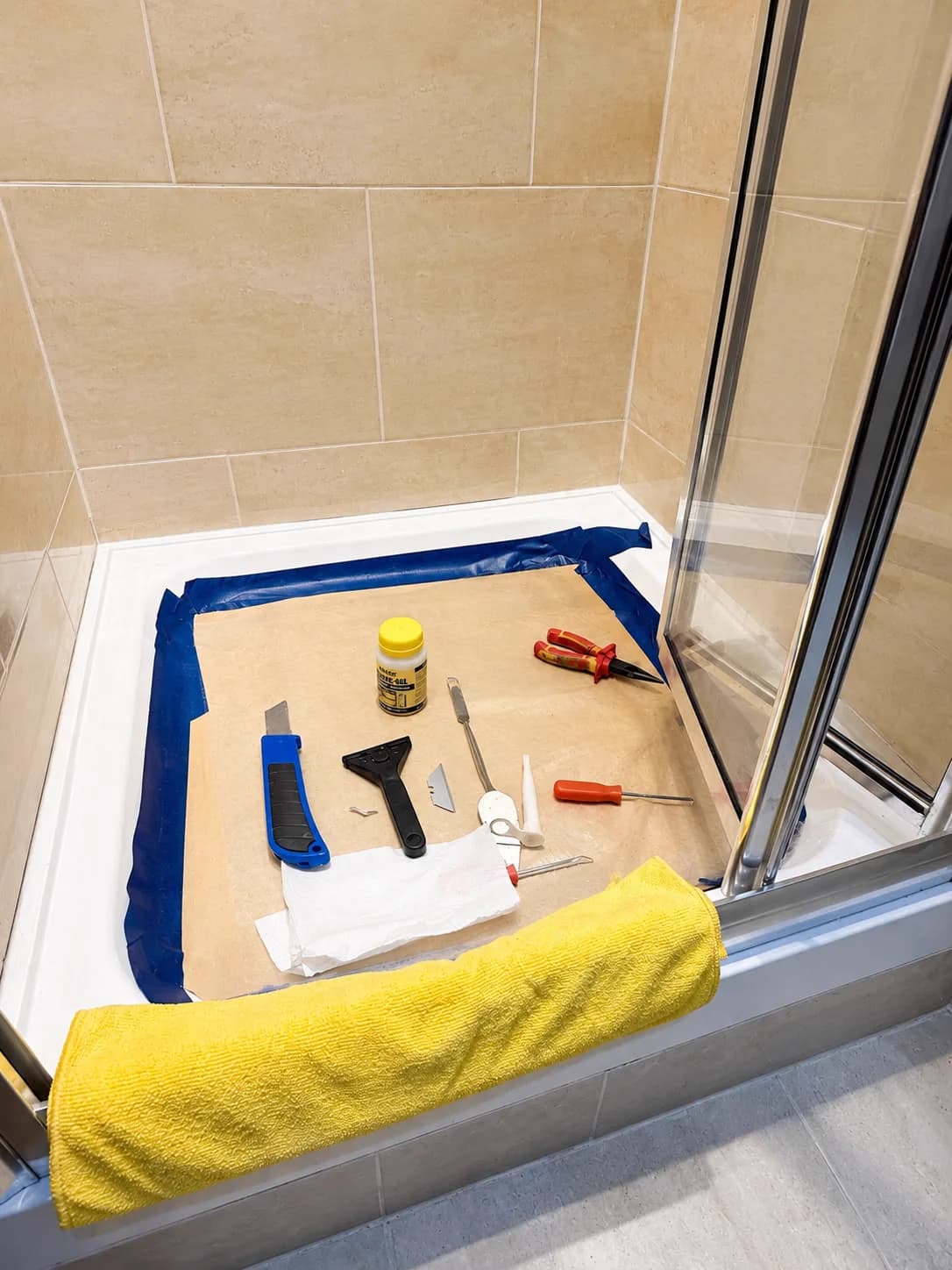 Tools protected inside a shower enclosure during repair work.