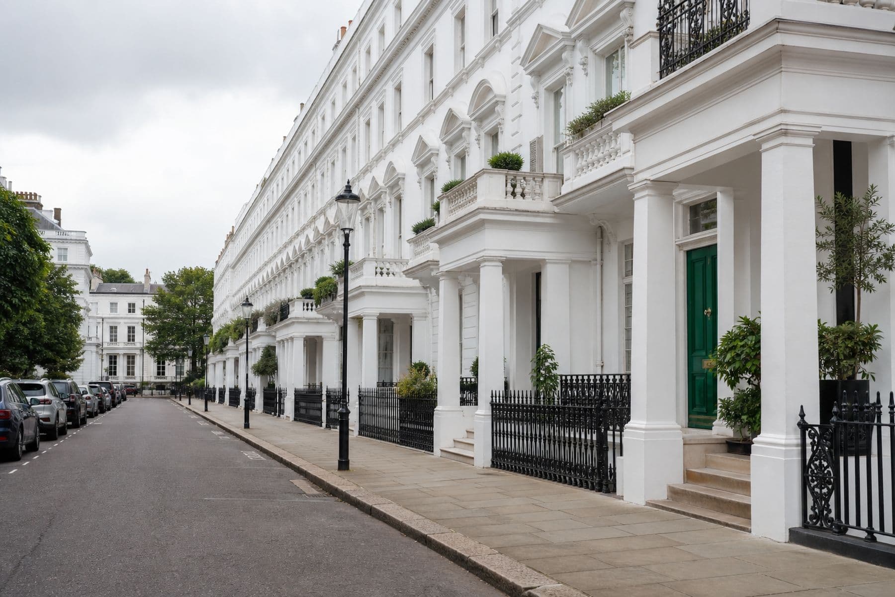 White stucco terraced street in Belgravia with iron railings and a green front door