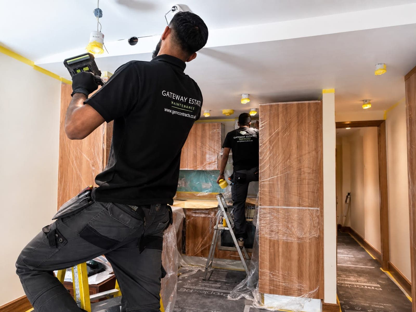 Two GEM operatives working on a kitchen refurbishment with floors and units under protection